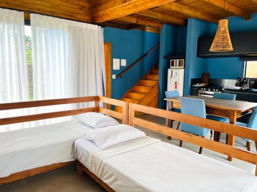 因比图巴Casa com Banheira, Piscina e Quadra de Areia的配有蓝色墙壁和厨房的客房内的两张床