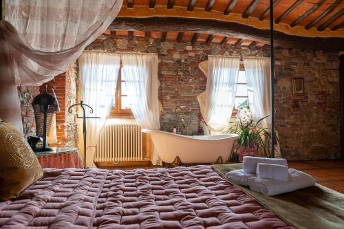 卢卡Luxury Corte Di Re Artù的一间卧室设有一张大床和一个浴缸