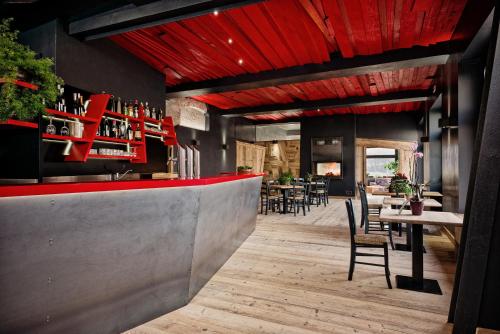 福尔加里亚意大利安蒂科阿尔贝哥斯黛拉酒店的餐厅设有红色酒吧,配有桌椅