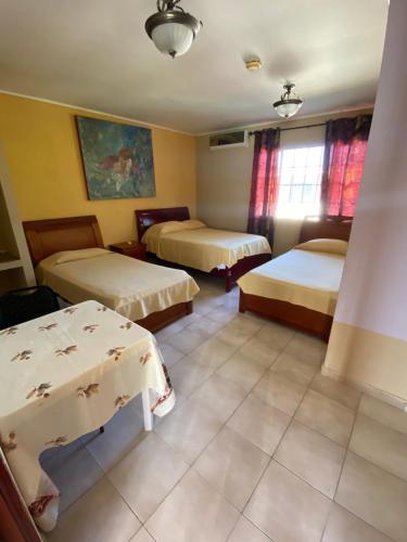 巴拿马城Canal Inn B&B Panama的酒店客房设有两张床和一张桌子。