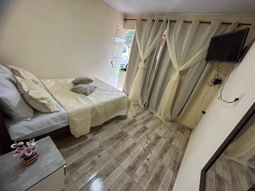 卡兰卡斯Pousada Sal da Terra的一间小卧室,配有一张床和电视