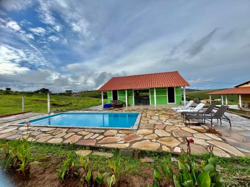 卡兰卡斯Pousada Sal da Terra的一个带游泳池和房子的后院