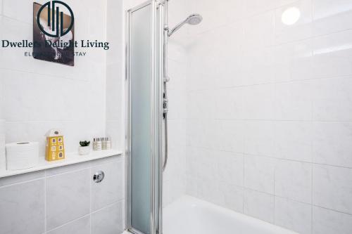 伍德福德格林Dwellers Delight Living Ltd Serviced accommodation 2 Bed House, free Wifi & Parking, Prime Location London, Woodford的浴室里设有玻璃门淋浴
