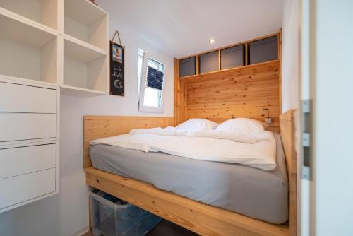 KarninHafenresort Karnin Hausboot Glaukos的一间卧室配有一张带木制床头板的床