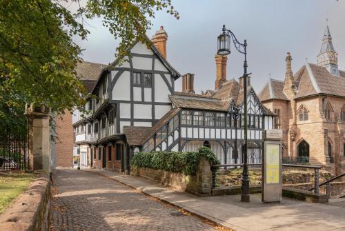 考文垂Coventry Historic Houses的白色和黑色的古老建筑,有街灯