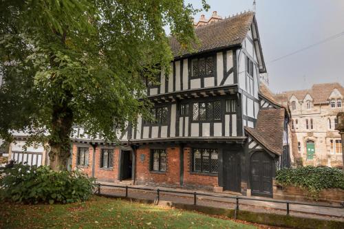 考文垂Coventry Historic Houses的一座黑白的古老建筑,有树