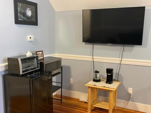 波士顿Comfortable loft with private bathroom的客厅配有电视、微波炉和桌子