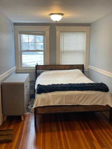 波士顿Comfortable loft with private bathroom的一间卧室设有一张床和两个窗户。
