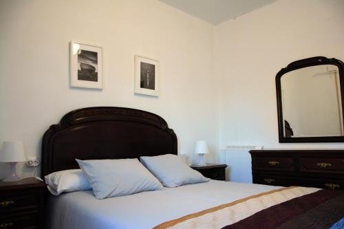 里贝拉Piso da Horta en Aguiño, Ribeira, Galicia的一间卧室配有一张大床和大镜子
