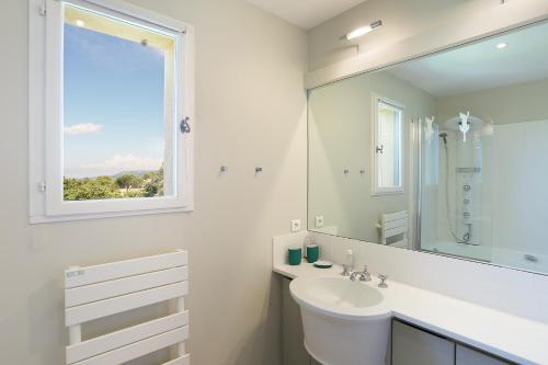 马莱莫尔Villa Briali Pont Royal的白色的浴室设有水槽和窗户。