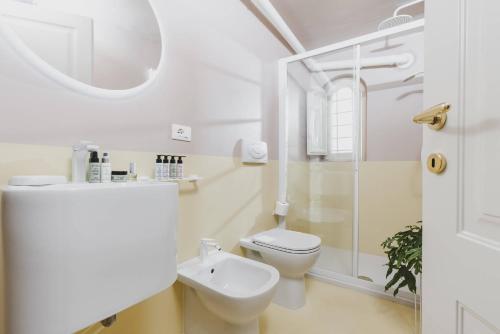 拉奎拉Casa Horti Suites的白色的浴室设有卫生间和水槽。