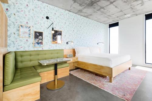奥斯汀ARRIVE Austin的一间卧室配有一张床和一张绿色沙发