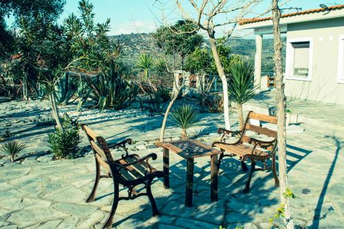 阿斯特里斯Giola aparments and studios 2的庭院配有三把椅子、一张桌子和一张桌子
