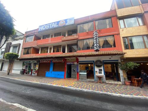 巴尼奥斯Hostal los Andes的街道边的一座带雨伞的建筑