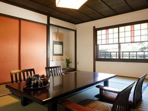 仓敷吉井日式旅馆的一间带木桌和椅子的用餐室