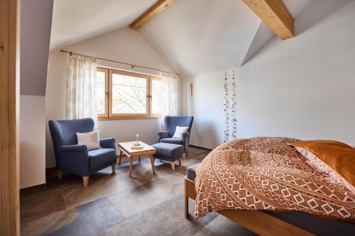 奥芬堡Biopension Satya的一间卧室配有两把椅子、一张床和一张桌子