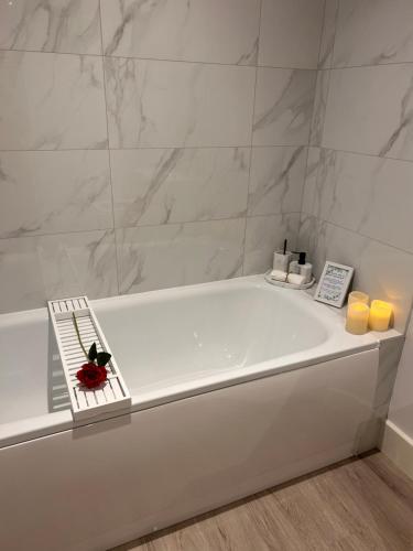 尚克林The Bay house Apartments , shanklin的浴室设有白色浴缸,拥有大理石墙壁。