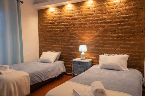 埃武拉Casa da Ti´Lola的砖墙客房的两张床