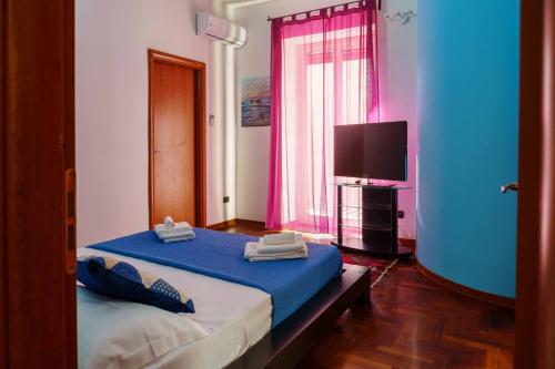 卡塔尼亚AmoCatania Apartment的一间卧室配有蓝色的床和电视