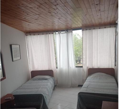 Puerto ViejoCondominio Victoria Real - Apartamento 202的带窗户的客房内的两张床