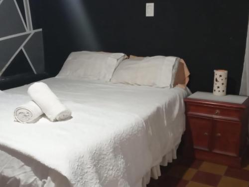 圣萨尔瓦多德朱Casa kukycita的一张白色的床,上面有两卷毛巾