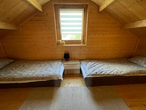 SierpcSiedlisko Anna Joniak的木间设有两张床,设有窗户