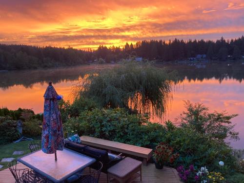 伍丁维尔Cottage Lake Bed and Breakfast的坐在湖前野餐桌上的连衣裙