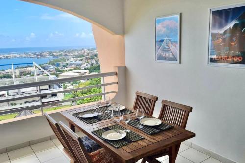 帕皮提Appartement Hana Iti breathtaking on the ocean at the entrance of Papeete的一间带桌椅的用餐室和一个阳台