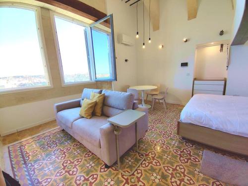 瓦莱塔Port 531 Savynomad Harbour Residences Valletta wow Views的一间带沙发、床和桌子的卧室