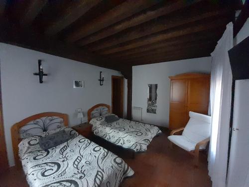 SotoserranoHotel Rural Sierra de Francia的卧室配有两张床,墙上有一个十字架