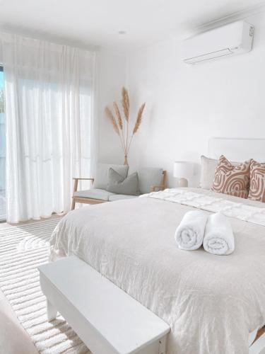 沃纳姆堡The Hideaway - Guest House的白色卧室配有带毛巾的大型白色床