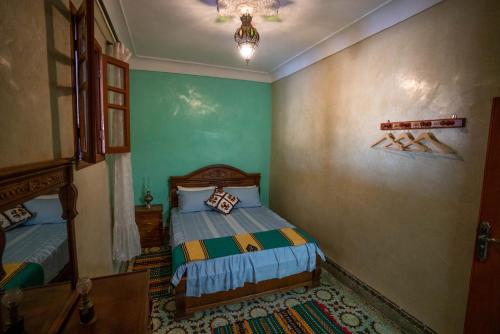 非斯Dar El Karam Fez的一间带两张床和吊灯的小卧室