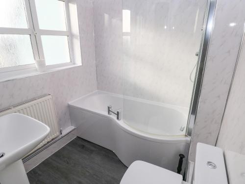 桑德斯富特Driftwood House的白色的浴室设有浴缸和水槽。