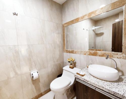 曼塔Katamar的一间带卫生间、水槽和镜子的浴室