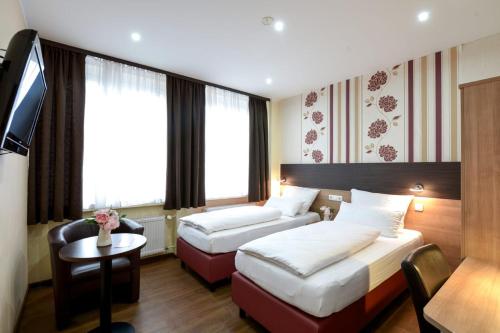 汉诺威城市全景酒店的一间酒店客房,设有两张床和电视