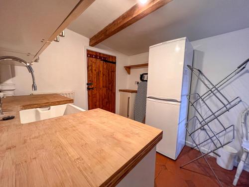 诺里奇Stylish 4 bed house with parking in central Norwich的厨房配有白色冰箱和木制柜台。