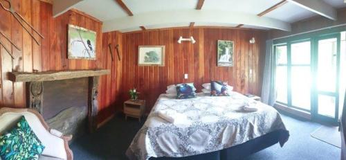 WaimihaBlackfern Lodge的卧室配有一张床铺,位于带木墙的房间内