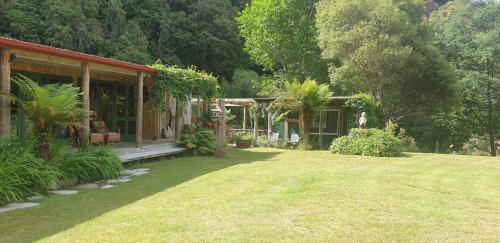 WaimihaBlackfern Lodge的一座带花园的房子和一座带房子的庭院