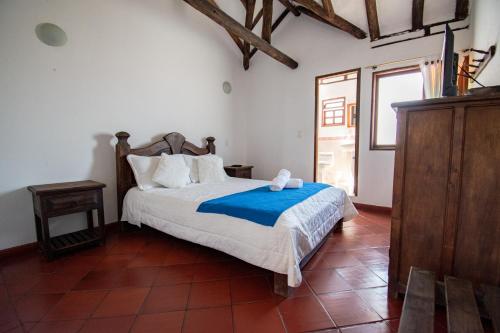 莱瓦镇月神别墅酒店的一间卧室配有一张带蓝色毯子的床