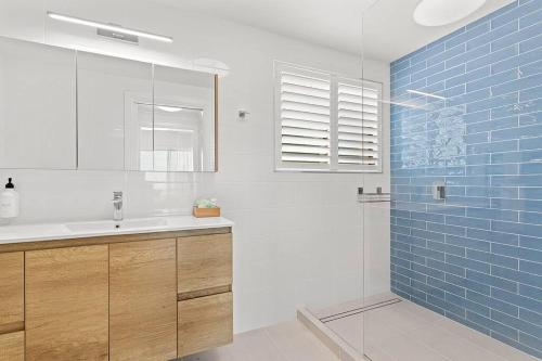 埃尔利海滩Aqua Vista的浴室设有水槽和蓝色瓷砖淋浴。