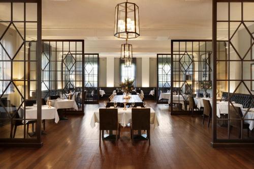 赫本温泉Mineral Springs Hotel Hepburn的餐厅设有白色的桌椅和窗户。