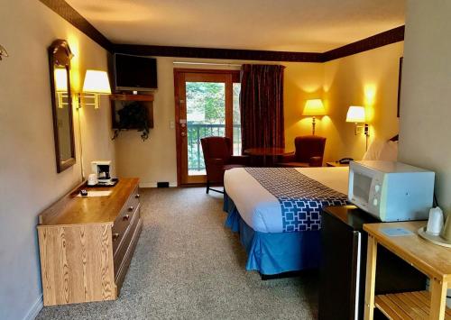 马吉谷四季汽车旅馆的配有一张床和一张书桌的酒店客房
