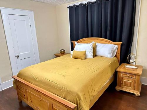 梅肯Southern Comfort Retreat的一间卧室配有一张带黄色床单和蓝色窗帘的床。