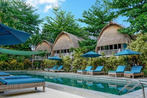 蓝梦岛海潮海滩度假酒店的度假村的游泳池,配有椅子和遮阳伞