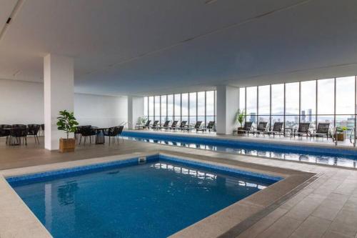 瓜达拉哈拉Moderno Bien Ubicado , Piscina A97c的大楼内带桌椅的大型游泳池