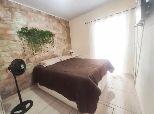 贝洛奥里藏特Kitnet Lua - Mobiliada的一间卧室设有一张床和砖墙