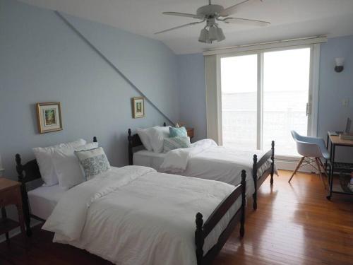  东港Casa al Mare Beachfront Retreat King Bed Near Yale的一间卧室配有两张床和吊扇