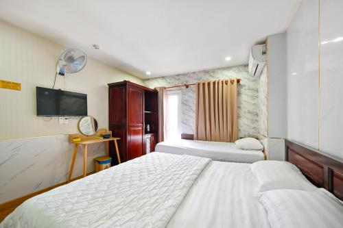 胡志明市Gia Hoa Airport Hotel的一间酒店客房,设有两张床和电视