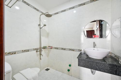 胡志明市Gia Hoa Airport Hotel的一间带水槽、卫生间和镜子的浴室