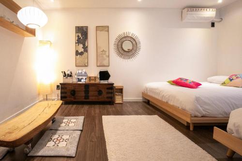 首尔Bias K-girl Guesthouse - Women only的一间卧室配有两张床、一张桌子和一面镜子